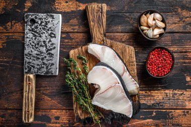 Kesme tahtasında satırla Mavi Köpekbalığı çiğ bifteği. Koyu ahşap arka plan. Üst görünüm