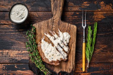 Biftek bifteği ve ahşap tahtada biber sosu. Koyu ahşap arka plan. Üst görünüm