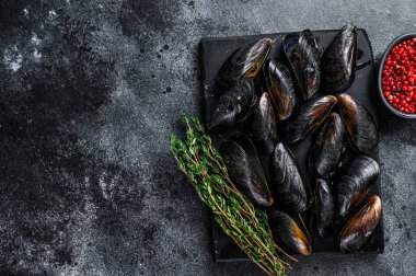 Mermer bir tahtanın üzerinde kaynamış midyeler. Siyah arka plan. Üst Manzara. Boşluğu kopyala