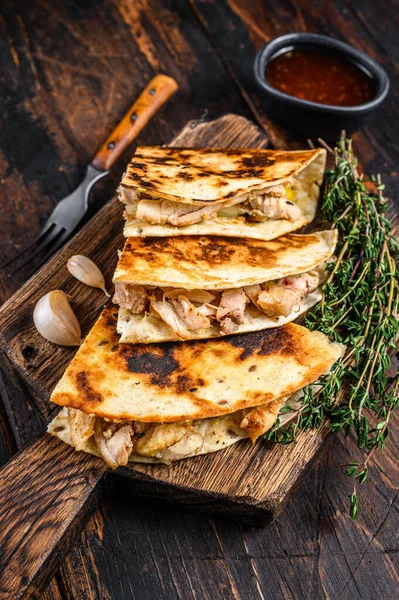 Mexikanska quesadilla med kyckling, paprika, ost och koriander på trä skärbräda. Mörk trä bakgrund. Ovanifrån — Stockfoto