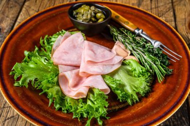 Taze salata ve kapari ile dilimlenmiş füme jambon. Ahşap arka plan. Üst görünüm