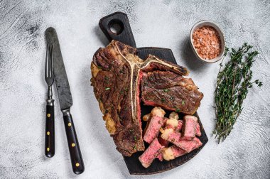 Tahta kesme tahtasında dilimlenmiş biftek bifteği. Beyaz arka plan. Üst görünüm