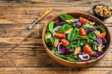 Yapraklı taze sebze salatası. Mangold, İsviçre pazısı, ıspanak, roka ve fındık. Ahşap arka plan. Üst Manzara. Boşluğu kopyala