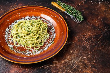 Pesto soslu ve parmesanlı ıspanaklı spagetti. Karanlık arka plan. Üst Manzara. Boşluğu kopyala