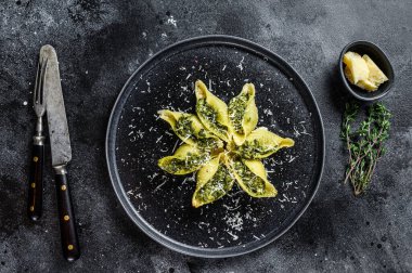 Konkiloni İtalyan Jumbo kabuklu Konchiglioni makarnası sığır eti ve ıspanakla dolu bir tabak. Siyah arka plan. Üst görünüm