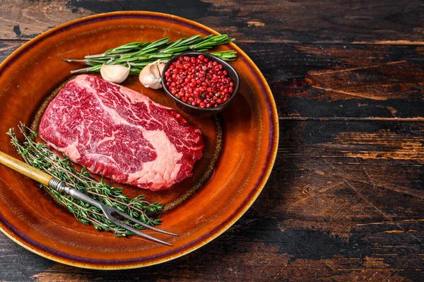 Kırsal bir tabakta siyah angus bifteği. Koyu ahşap arka plan. Üst Manzara. Boşluğu kopyala