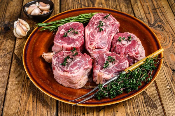Mutton carne de cordero en un plato rústico con tomillo y romero. fondo de madera. Vista superior —  Fotos de Stock