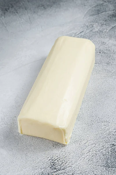 Pedaço de manteiga fresca para o pequeno-almoço na mesa da cozinha. Fundo branco. Vista superior — Fotografia de Stock
