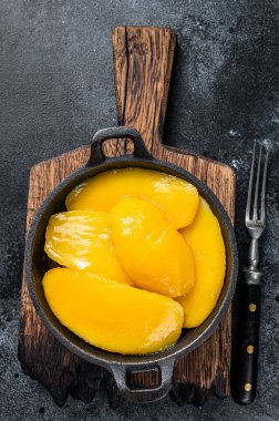 Kasede konserve mango dilimleri. Siyah arka plan. Üst görünüm