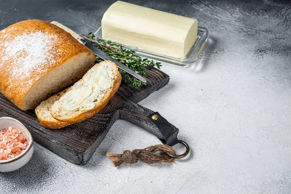 Boterblok en gesneden brood op een houten bord met kruiden. Witte achtergrond. Bovenaanzicht. Kopieerruimte — Stockfoto