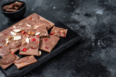 Mermer tahtada el yapımı çikolatalar. Siyah arka plan. Üst Manzara. Boşluğu kopyala