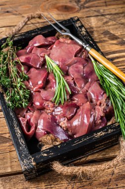 Tahta tepside taze çiğ tavuk ciğeri ve et. Ahşap arka plan. Üst görünüm