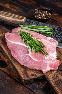 Mutfak arka planında baharat ve malzemelerle kesilmiş taze çiğ domuz eti. Koyu ahşap arka plan. Üst görünüm