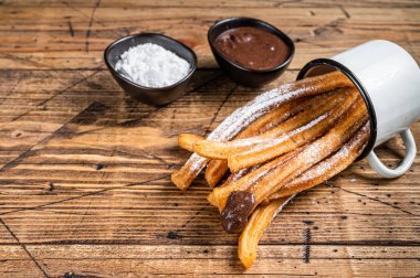 Şeker ve çikolata soslu Churros. Ahşap arka plan. Üst Manzara. Boşluğu kopyala