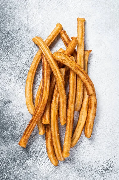 Churros frito palos en la mesa de la cocina. Fondo blanco. Vista superior —  Fotos de Stock