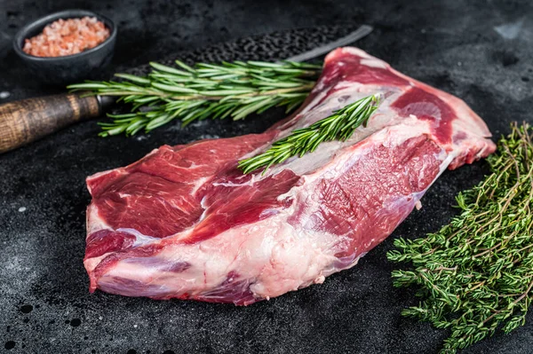 Carne fresca di agnello crudo o di capra con coltello da macellaio. Fondo nero. Vista dall'alto — Foto Stock