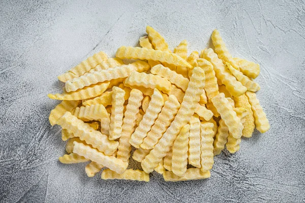 Bevroren kreukelfrietjes aardappelstokjes. Witte achtergrond. Bovenaanzicht — Stockfoto