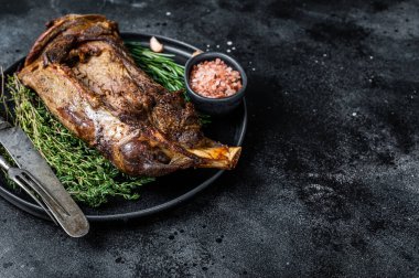 Bıçak ve çatalla tabakta kızarmış koyun eti. Siyah arka plan. Üst Manzara. Boşluğu kopyala