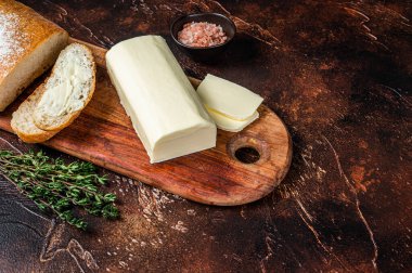 Tahta kesme tahtasına tereyağlı dilimlenmiş tost ekmeği. Karanlık arka plan. Üst Manzara. Boşluğu kopyala