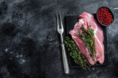 Misket tahtasında kesilmiş çiğ domuz eti. Siyah arka plan. Üst Manzara. Boşluğu kopyala