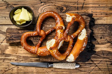 Köy ahşap kesme tahtasının üzerinde deniz tuzu ile pişirilmiş krakerler. Ahşap arka plan. Üst görünüm