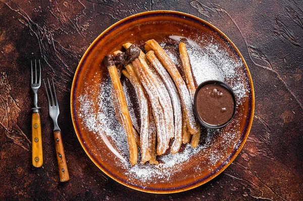 Churros de tapas españolas con salsa de azúcar y chocolate. Fondo oscuro. Vista superior — Foto de Stock