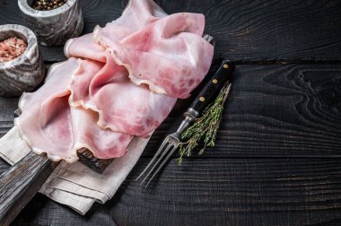 Tahtada otlarla dilimlenmiş jambon. Siyah ahşap arka plan. Üst Manzara. Boşluğu kopyala