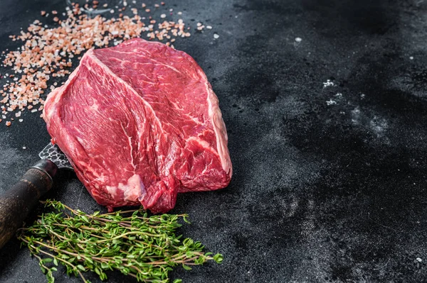 Mezbaha bıçağında çiğ biftek. Siyah arka plan. Üst Manzara. Boşluğu kopyala