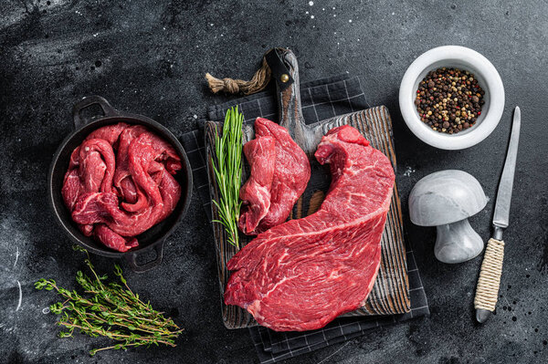 Beef fillet round cut Sliced on a butcher cutting board. Black background. Top view