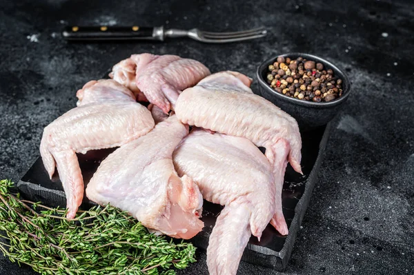 Raw chicken wings Poultry meat on a marble board. Black background. Top view — Stock Photo, Image