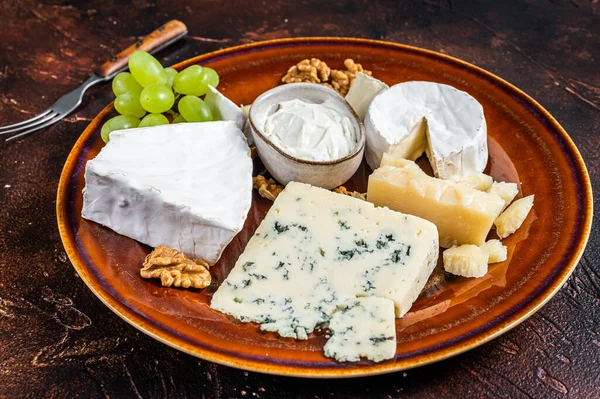 Prato de queijo com Brie, Camembert, Roquefort, queijo creme azul, uva e nozes. Fundo escuro. Vista superior — Fotografia de Stock