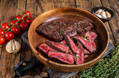 Ahşap bir tabakta dilimlenmiş üst bıçak ya da Denver bifteği. Ahşap arka plan. Üst görünüm