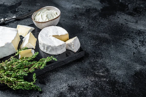 Käseplatte vorhanden. Camembert, Brie, Gorgonzola und Blauschimmelkäse mit Thymian. Schwarzer Hintergrund. Ansicht von oben. Kopierraum — Stockfoto