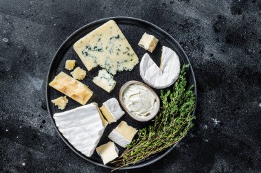Fransız peyniri tabağı. Camembert, Brie, Gorgonzola ve mavi krem peynir. Siyah arka plan. Üst görünüm