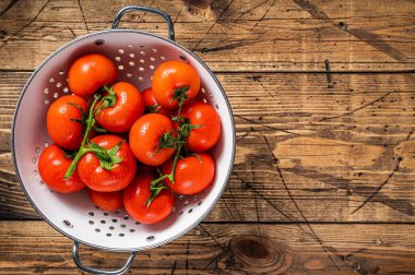 Kevgir soslu kırmızı kiraz domatesleri. Ahşap arka plan. Üst Manzara. Boşluğu kopyala