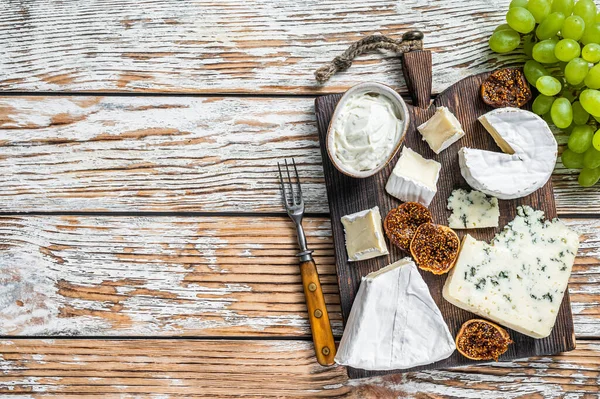 Tábua de queijo com brie, Camembert, Gorgonzola e queijo cremoso azul. Fundo de madeira branco. Vista superior. Espaço de cópia — Fotografia de Stock