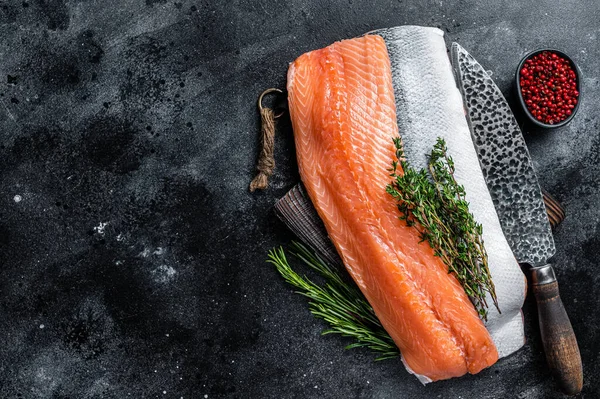 Pesce filetto di salmone crudo fresco sul tagliere con coltello. Fondo nero. Vista dall'alto. Copia spazio — Foto Stock