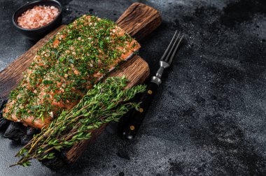 Gravlax ahşap tahtada dereotlu ve tuzlu somonu tedavi etti. Siyah arka plan. Üst Manzara. Boşluğu kopyala