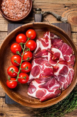 İtalyan dilimlenmiş baharatlı koppa jambonu. Ahşap arka plan. Üst görünüm