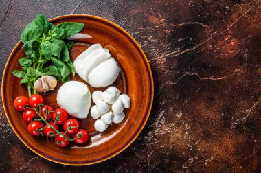 Mozzarella peyniri, fesleğen ve domates kirazı Caprese salatası pişirmeye hazır. Karanlık arka plan. Üst Manzara. Boşluğu kopyala