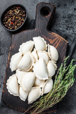 Tahta üzerinde patates olan dondurulmuş çiğ hamur tatlısı. Siyah arka plan. Üst Görünüm