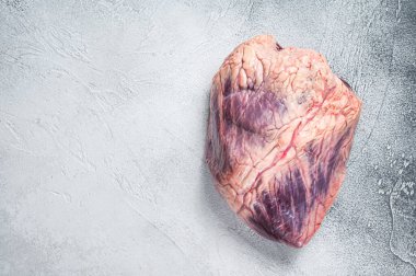 Kasap masasında sığır eti ya da çiğ kalp. Beyaz arka plan. Üst Manzara. Boşluğu kopyala