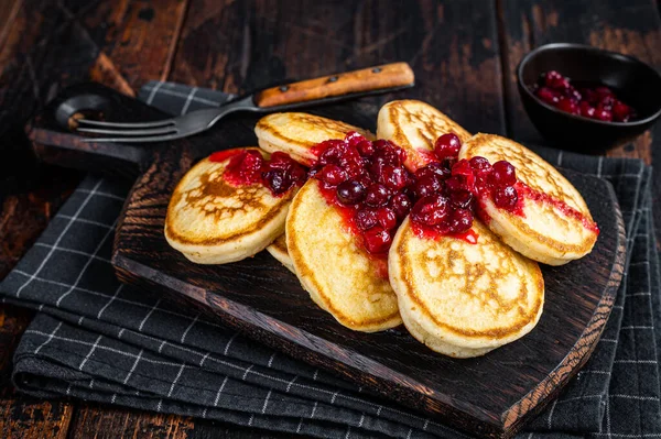 Stapelweise Preiselbeersirup-Pfannkuchen auf Holzbrettern. Dunkler Holzhintergrund. Ansicht von oben — Stockfoto