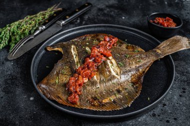 Kızarmış Flatfish veya domates soslu Flounder. Siyah arka plan. Üst görünüm
