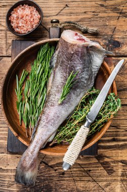 Çiğ morina ya da ahşap tabakta otlu morina balığı. Ahşap arka plan. Üst görünüm