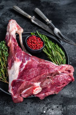 Keçi eti ya da kuzu eti, kemiğe otlar sürülmüş. Siyah arka plan. Üst Manzara. Boşluğu kopyala