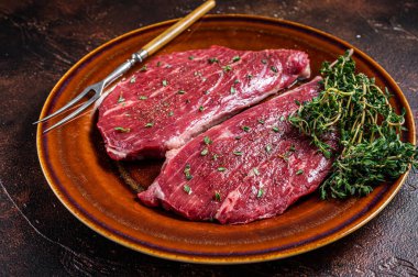 Çiğ biftek ya da kekik ve zeytinyağlı sığır etli sığır filetosu. Karanlık arka plan. Üst görünüm