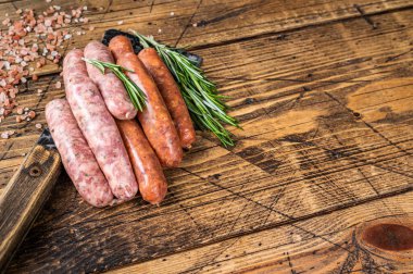 Bir kasap satırının üzerinde çiğ domuz eti ve sığır eti sosisi. Ahşap arka plan. Üst Manzara. Boşluğu kopyala