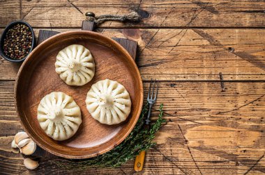 Ahşap tabakta kuzu etiyle haşlanmış Khinkali köftesi. Ahşap arka plan. Üst Manzara. Boşluğu kopyala