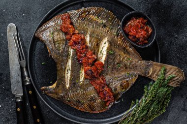 Kızarmış Flatfish veya domates soslu Flounder. Siyah arka plan. Üst görünüm